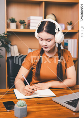 Homeschool Asian girl student learning virtual internet online class from school teacher by remote meeting. Female teaching math by headphone. education concept. student with computer study at school 129860954