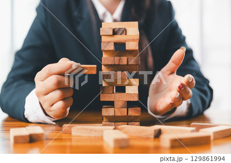 Business risk control concept, Businesswoman protect wooden block fall to planning and strategy in risk to business alternative and prevent. investment insurance business. Business risk control concept, Businesswoman protect wooden block fall to planning and strategy in risk to business alternative and prevent. investment insurance business. 129861994