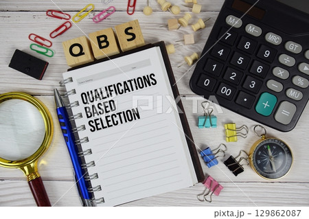 QBS Qualifications Based Selection acronym on notepad, business and financial concept background 129862087