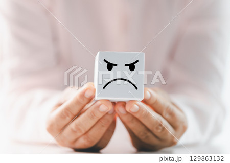 Close up customer hand choose sad face and blurred smiley face icon, Service rating, satisfaction concept. Negative feedback from client often reflects dissatisfaction with quality of service. 129863132