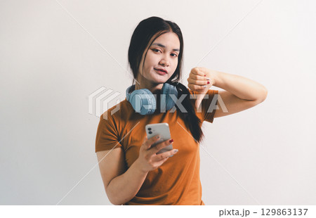 Asian girl expresses dislike, person express negative feeling, concept business complaint from customer ensuring employee satisfaction negative feedback to prevent mental strain customer dislike 129863137