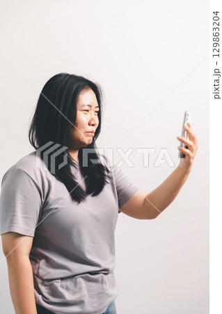 Asian girl expresses dislike, person express negative feeling, concept business complaint from customer ensuring employee satisfaction negative feedback to prevent mental strain customer dislike Asian girl expresses dislike, person express negative feeling, concept business complaint from customer ensuring employee satisfaction negative feedback to prevent mental strain customer dislike 129863204