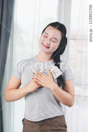 Business, finance and employment, entrepreneur and money concept. Successful young asian office manager, businesswoman showing earned cash, smiling satisfied holding dollars, money dollar bills Business, finance and employment, entrepreneur and money concept. Successful young asian office manager, businesswoman showing earned cash, smiling satisfied holding dollars, money dollar bills 129863706