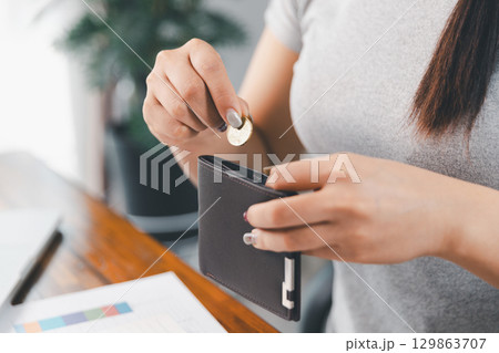Young Asian woman making stack of coin. invest save finance concept, saving money, investment. dollar bills on table with pile of coins and banks calculator, money to save and invest to make income. Young Asian woman making stack of coin. invest save finance concept, saving money, investment. dollar bills on table with pile of coins and banks calculator, money to save and invest to make income. 129863707