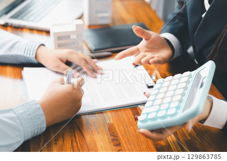 Home loan officer uses calculator with house plan loan real estate or property. important to loan calculator seek real estate, finance insurance advice ensure smart financial decisions for business. Home loan officer uses calculator with house plan loan real estate or property. important to loan calculator seek real estate, finance insurance advice ensure smart financial decisions for business. 129863785