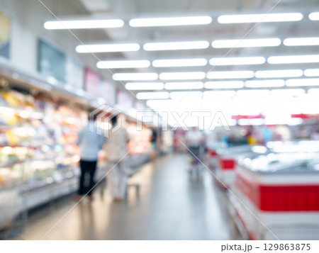 Blurred view of modern supermarket store background. Shopping in hypermarket superstore defocused bokeh light background. 129863875
