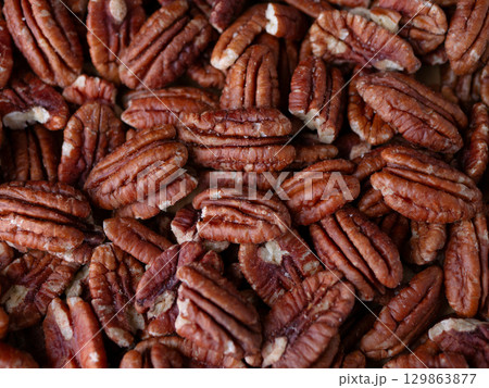 raw organic pecan nuts pattern background. raw organic pecan nuts pattern background. 129863877