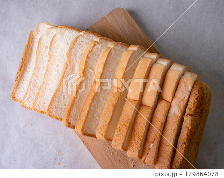 Toasted white bread loaf sliced on white background. Toasted white bread loaf sliced on white background. 129864078