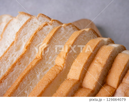 Toasted white bread loaf sliced on white background. Toasted white bread loaf sliced on white background. 129864079