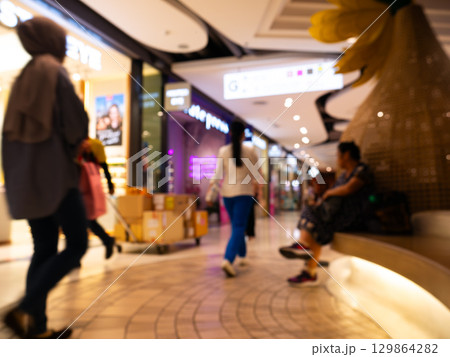 Blurred motion of people shopping inside modern shopping mall interior. Blurred motion of people shopping inside modern shopping mall interior. 129864282