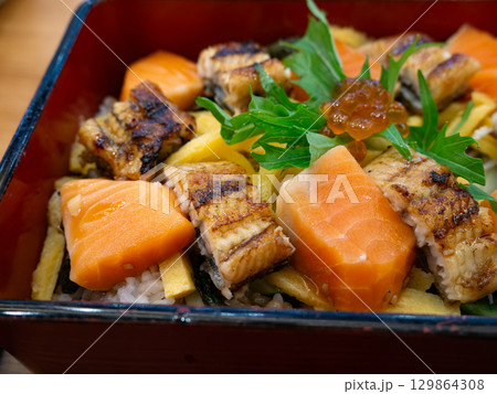 Japanese Bento Box with Unagi Don and Salmon Sashimi. Grilled Eel and Fresh Salmon on rice set. 129864308