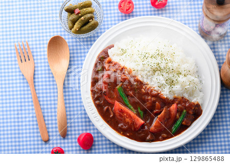 ほかほかと香り立つトマトカレーと白ごはんの盛り付け　サラダ付き家庭料理の食卓イメージ 129865488