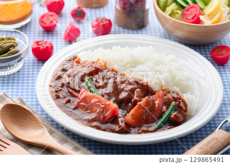 ほかほかと香り立つトマトカレーと白ごはんの盛り付け サラダ付き家庭料理の食卓イメージ ほかほかと香り立つトマトカレーと白ごはんの盛り付け サラダ付き家庭料理の食卓イメージ 129865491