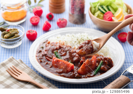 ほかほかと香り立つトマトカレーと白ごはんの盛り付け　サラダ付き家庭料理の食卓イメージ 129865496