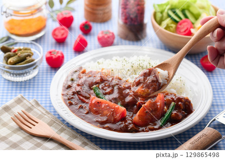 ほかほかと香り立つトマトカレーと白ごはんの盛り付け　サラダ付き家庭料理の食卓イメージ 129865498