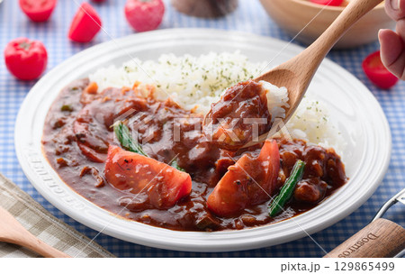 ほかほかと香り立つトマトカレーと白ごはんの盛り付け　サラダ付き家庭料理の食卓イメージ 129865499