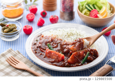 ほかほかと香り立つトマトカレーと白ごはんの盛り付け サラダ付き家庭料理の食卓イメージ ほかほかと香り立つトマトカレーと白ごはんの盛り付け サラダ付き家庭料理の食卓イメージ 129865500