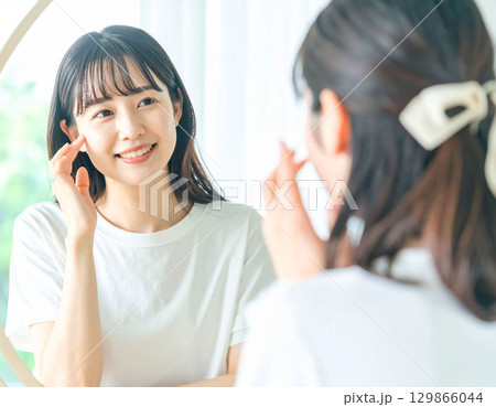 鏡を見る若い女性 129866044