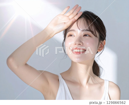 日差しの中の若い女性 129866562