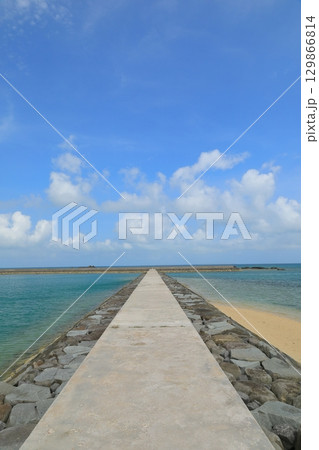 青い海へとまっすぐに伸びる小浜島海人公園の防波堤の道 129866814