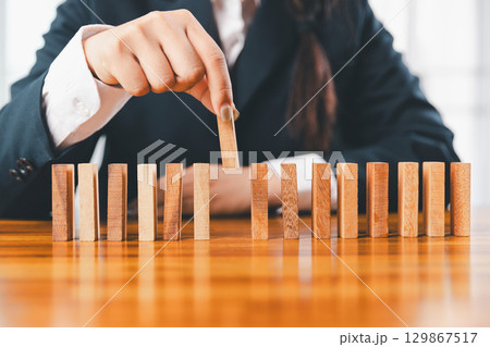 Business risk control concept, Businesswoman protect wooden block fall to planning and strategy in risk to business alternative and prevent. investment insurance business. Business risk control concept, Businesswoman protect wooden block fall to planning and strategy in risk to business alternative and prevent. investment insurance business. 129867517