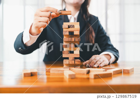 Business risk control concept, Businesswoman protect wooden block fall to planning and strategy in risk to business alternative and prevent. investment insurance business. Business risk control concept, Businesswoman protect wooden block fall to planning and strategy in risk to business alternative and prevent. investment insurance business. 129867519