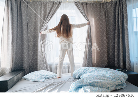 A girl with long hair enjoys a peaceful awakening early in the morning. A girl with long hair enjoys a peaceful awakening early in the morning. 129867610