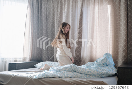 A girl with long hair enjoys a peaceful awakening early in the morning. A girl with long hair enjoys a peaceful awakening early in the morning. 129867648