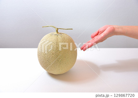 マスクメロン(熊本県産)をどうぞと手を差し出す女性 マスクメロン(熊本県産)をどうぞと手を差し出す女性 129867720