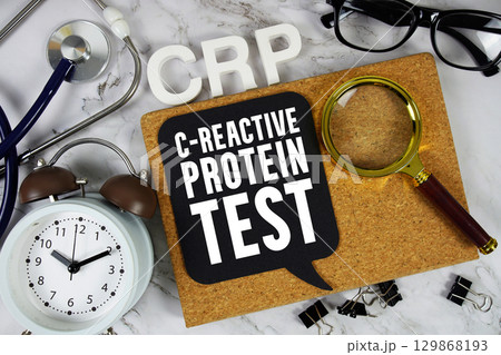 CRP - C-Reactive Protein Test text with Stethoscope, alarm clock and magnifying glass on marble background 129868193