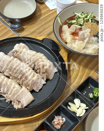 Suyuk, a traditional Korean dish of boiled pork slices, tender and juicy, often served with salted shrimp sauce, garlic, and ssamjang. Perfect for wrapping in lettuce for a flavorful, balanced bite. Suyuk, a traditional Korean dish of boiled pork slices, tender and juicy, often served with salted shrimp sauce, garlic, and ssamjang. Perfect for wrapping in lettuce for a flavorful, balanced bite. 129868839