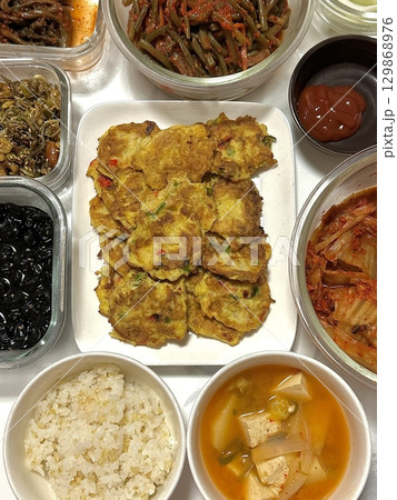 A vibrant spread of Korean food on the table, featuring various banchan (side dishes) like kimchi, pickled vegetables, and seasoned greens. Perfect for food photography, showcasing traditional Korean. A vibrant spread of Korean food on the table, featuring various banchan (side dishes) like kimchi, pickled vegetables, and seasoned greens. Perfect for food photography, showcasing traditional Korean. 129868976