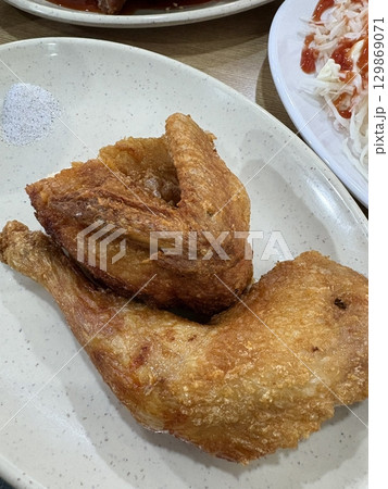 Crispy Korean fried chicken, perfectly glazed with a sweet and spicy sauce. Ideal for food photography and menus, showcasing the irresistible crunch and flavor of this beloved dish. Crispy Korean fried chicken, perfectly glazed with a sweet and spicy sauce. Ideal for food photography and menus, showcasing the irresistible crunch and flavor of this beloved dish. 129869071