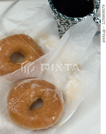 A classic glazed donut with a soft, fluffy texture and a sweet, glossy coating. Perfectly balanced between light and sugary, making it an irresistible treat for any time of the day. 129869079