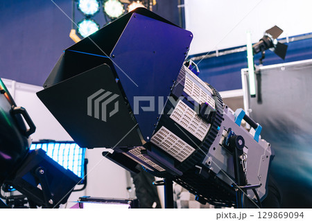Professional studio LED close-up spotlight. Modern equipment for film, television and photo studios. Metal case with cooling, the front part is equipped with light-forming elements. Professional studio LED close-up spotlight. Modern equipment for film, television and photo studios. Metal case with cooling, the front part is equipped with light-forming elements. 129869094