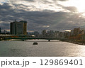 夕日に染まる隅田川と一艘の船 129869401
