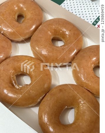 A classic glazed donut with a soft, fluffy texture and a sweet, glossy coating. Perfectly balanced between light and sugary, making it an irresistible treat for any time of the day. A classic glazed donut with a soft, fluffy texture and a sweet, glossy coating. Perfectly balanced between light and sugary, making it an irresistible treat for any time of the day. 129869459