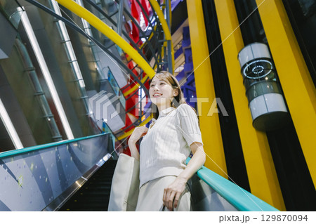 デパートのエスカレーターに乗る女性 デパートのエスカレーターに乗る女性 129870094