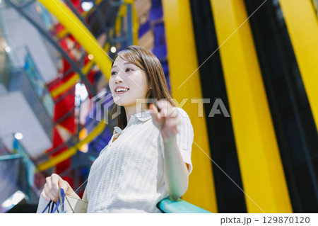 デパートのエスカレーターに乗る女性 129870120