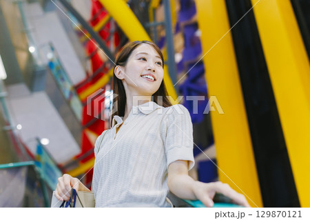 デパートのエスカレーターに乗る女性 129870121
