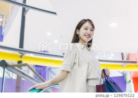 デパートのエスカレーターに乗る女性 129870122
