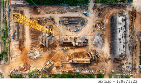 Construction site with crane, excavator, and scaffolding. design for building and development projects top view. 129871222