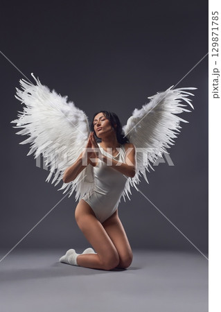 Graceful woman in underwear with feather wings praying to the God Graceful woman in underwear with feather wings praying to the God 129871785