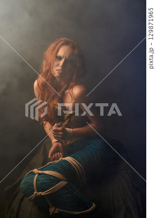 Aggressive mermaid getting out of trap in studio 129871965