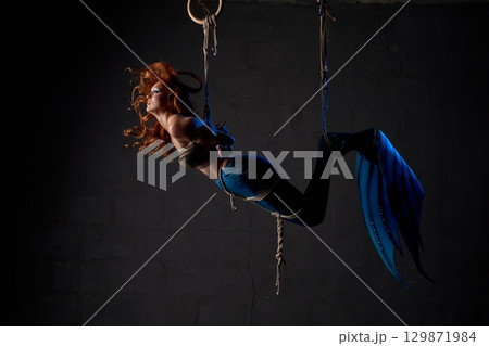 Mermaid trapped in ropes against black background 129871984