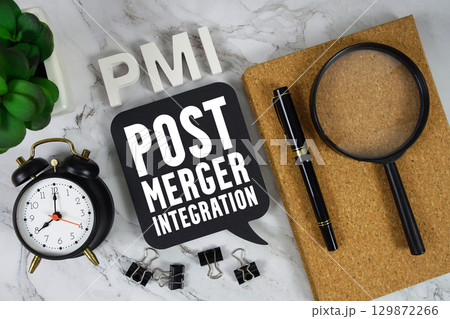 PMI Post-merger Integration text with alarm clock and magnifying glass on marble background 129872266