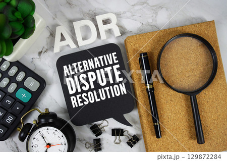 ADR Alternative Dispute Resolution text with Calculator, alarm clock and magnifying glass on marble background ADR Alternative Dispute Resolution text with Calculator, alarm clock and magnifying glass on marble background 129872284