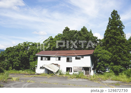 夏草茂る崩れかけた廃スキー場の施設 129872730