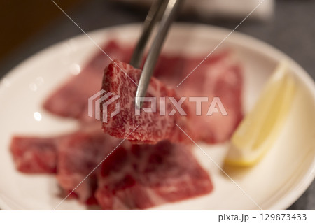 トングで持ち上げた但馬牛の美しい霜降り肉 129873433