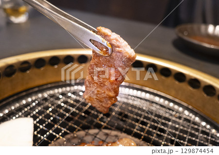 トングで持ち上げた飛騨牛上カルビ 129874454